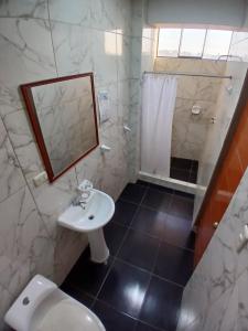 a bathroom with a sink and a shower and a toilet at Hotel Residencial San Isidro in Hualmay