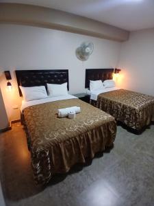 two beds in a hotel room with towels on them at Hotel Residencial San Isidro in Hualmay +8 photos
