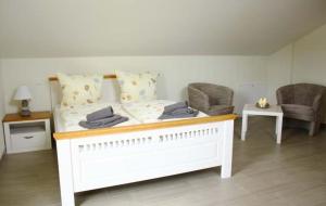a white bed in a room with two chairs at Sonnenschein in Lenz