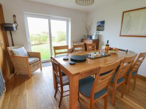 a dining room with a wooden table and chairs at Yr Orsedd in Holyhead