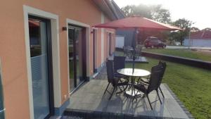 a patio with a table and chairs and an umbrella at Haus Phil in Lenz