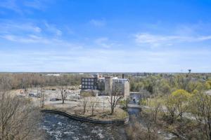 an aerial view of a building with a river and trees at Tri Century Mill Suites in Carleton Place