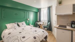 a bedroom with a bed and a green wall at Manu Chalons in Chalons en Champagne