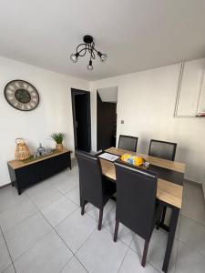 a dining room with a wooden table and chairs at Maison de ville Chauny in Chauny