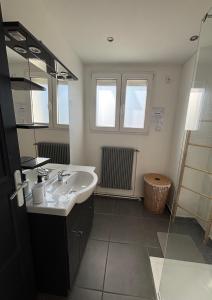 a bathroom with a sink and a shower at Maison de ville Chauny in Chauny