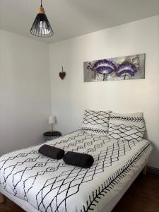 a bedroom with a bed with a black and white comforter at Maison de ville Chauny in Chauny