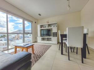 a living room with a television and a table and chairs at Brisa Austral Comodoro in Comodoro Rivadavia