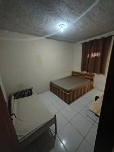 a small room with two beds and a window at Pousada Rancho in Angra dos Reis