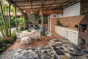 a patio with a table and chairs and a fireplace at Pousada Rancho in Angra dos Reis