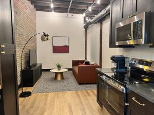 a kitchen and living room with a couch in a room at Brick & Bed Riverfront Lofts, T 410 in Saint Louis
