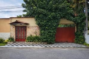 a house with a red door and a tree at Pousada Rancho in Angra dos Reis +3 photos