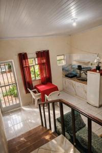 a room with a kitchen with a table and a refrigerator at Pousada Rancho in Angra dos Reis