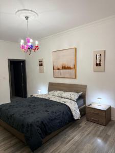 a bedroom with a bed and a chandelier at Room in sliema's heart in Il-Gżira +6 photos