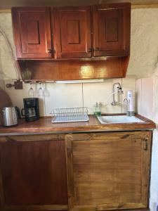a kitchen with wooden cabinets and a sink at Eywa in Punta Del Diablo +7 photos