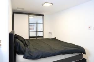 a bed in a room with a window at The Apartment in Oldham +4 photos