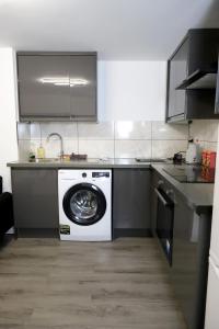 a kitchen with a washing machine and a washer at The Apartment in Oldham