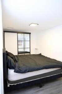 a bed in a room with a large window at The Apartment in Oldham