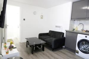 a living room with a chair and a washing machine at The Apartment in Oldham