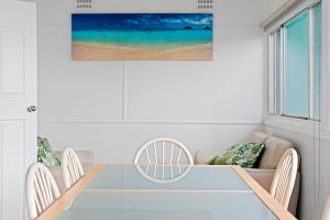 a dining room with a blue table and chairs at Sunbeam Cottage on the Lake in Toukley +23 photos