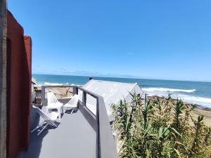 a balcony with two chairs and the beach at Eywa in Punta Del Diablo