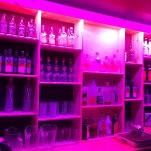 a room filled with lots of bottles in pink lights at Jeju Guesthouse Big SSUM in Seogwipo