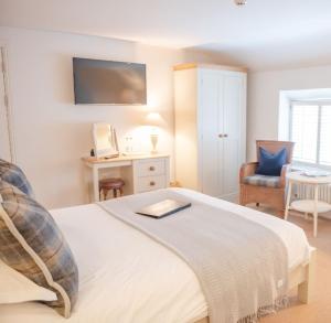 a bedroom with a bed and a desk and a chair at The Bell at Hampton Poyle in Kidlington