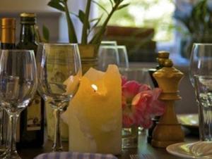 a table with wine glasses and a candle and flowers at The Bell at Hampton Poyle in Kidlington