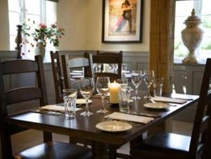 a wooden table with glasses and a candle on it at The Bell at Hampton Poyle in Kidlington +3 photos