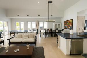 a kitchen and living room with a couch and a table at Amamare Waterfront Villa | Pool + Private Dock in Bailey Town