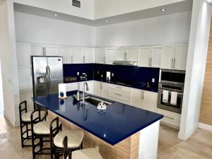 a kitchen with a blue counter top and a refrigerator at Amamare Waterfront Villa | Pool + Private Dock in Bailey Town