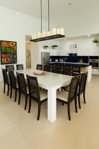 a dining room with a white table and chairs at Amamare Waterfront Villa | Pool + Private Dock in Bailey Town