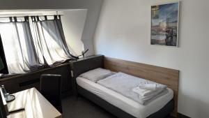 a small bed in a room with two windows at Hotel Belvedere in Seevetal +30 photos