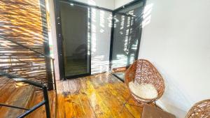 a balcony with a rattan chair and a window at Mr Pakal Tulum in Tulum