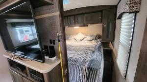 a bedroom with a bed and a tv in an rv at Rattrays Rd Farm Accomodation in Makikihi