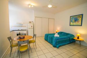 a bedroom with a bed and a table and chairs at Breakaway • Central Studio for 4 • Beach • Pool in Agnes Water