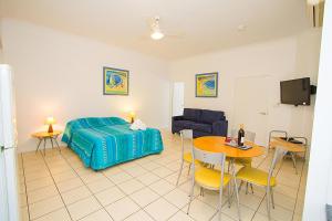 a bedroom with a bed and a table and chairs at Breakaway • Central Studio for 4 • Beach • Pool in Agnes Water