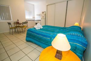 a bedroom with a bed and a table with a lamp at Breakaway • Central Studio for 4 • Beach • Pool in Agnes Water +6 photos