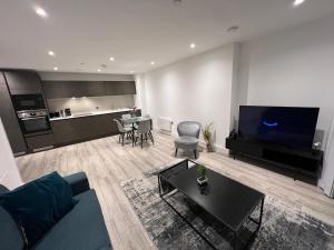 a living room with a blue couch and a kitchen at Luxe Penthouse 2 bed Deansgate in Manchester