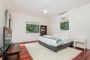 a bedroom with a bed and a flat screen tv at Merindah • Pet-Friendly • Central 4BDR for 10 in Agnes Water