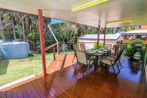 a patio with a table and chairs on a deck at McLeods • Pet-Friendly Central Beach House for 6 in Agnes Water