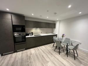 a kitchen with a table and chairs in a room at Luxe Penthouse 2 bed Deansgate in Manchester