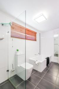 a bathroom with a toilet and a sink and a tub at On Agnes Time • Beach House for 10 • BBQ Deck • Walk to Beach in Agnes Water +36 photos