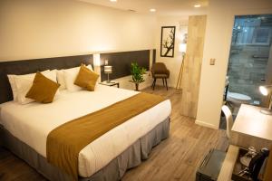 a hotel room with a large bed and a bathroom at Hotel Auramia in Punta Arenas