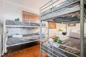 a room with two bunk beds in it at On Agnes Time • Beach House for 10 • BBQ Deck • Walk to Beach in Agnes Water