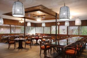 a dining room with tables and chairs and lights at Rimba Orangutan Ecolodge in Kampungcina