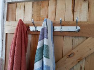 three towels are hanging on a wooden wall at Longonot Cabin in Longonot +18 photos