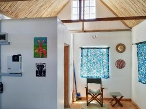 a room with a chair and paintings on the wall at Longonot Cabin in Longonot