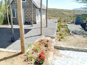a garden with a pole and flowers in front of a house at Longonot Cabin in Longonot