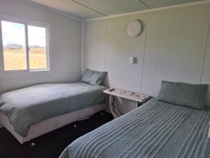 a room with two beds and a table and a window at Karamu Homestead in Karamu