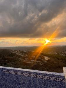 Blick auf den Sonnenuntergang von der Spitze eines Gebäudes in der Unterkunft Aroma Chalet in Ḩūmīn al Fawqā